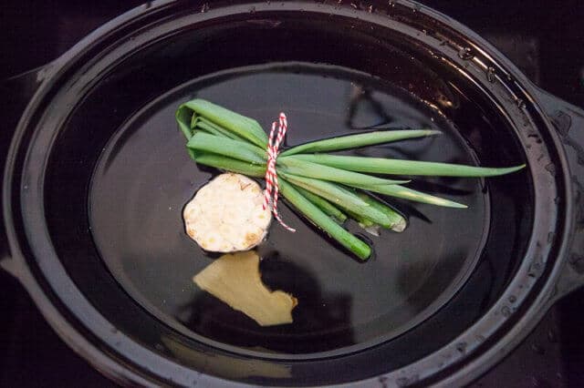 Slow Cooker Bone Broth Recipe - Asian Tie green onions with twine and slice ginger in half